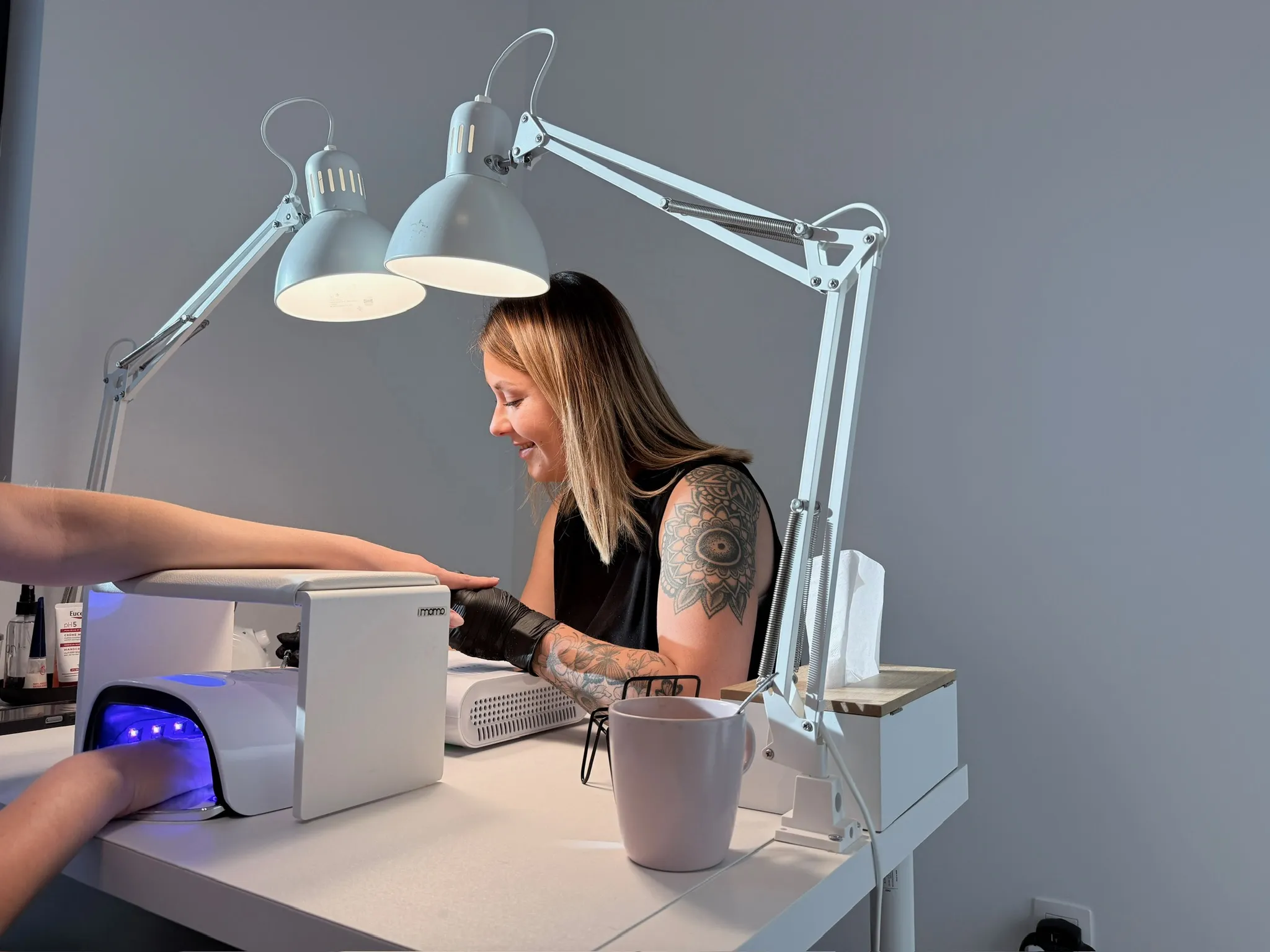 persoon met roze gelnagels met glitters die een pot roze glitters vasthoudt